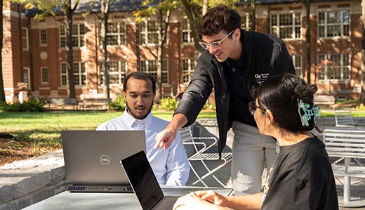 Picture of students at a table with laptops.